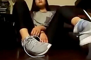 Chica asiática se quita los tenis y los calcetines