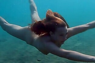 Julia is swimming underwater nude in the sea